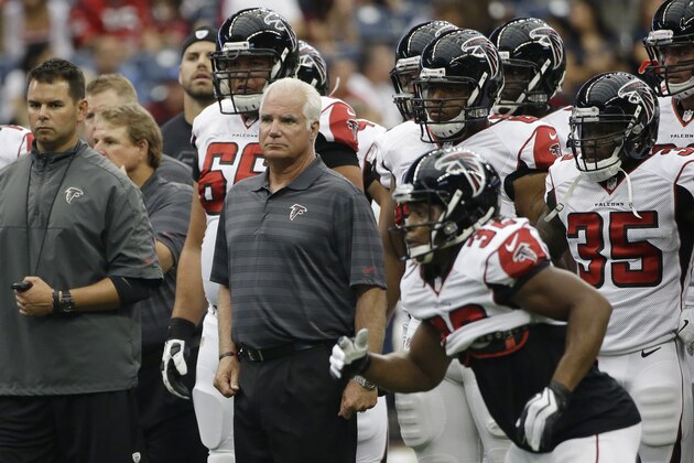Atlanta Falcons head coach Mike Smith, center, stand with his team before an NFL preseason football game against the Houston Texans, Saturday, Aug. 16, 2014, in Houston. (AP Photo/David J. Phillip)