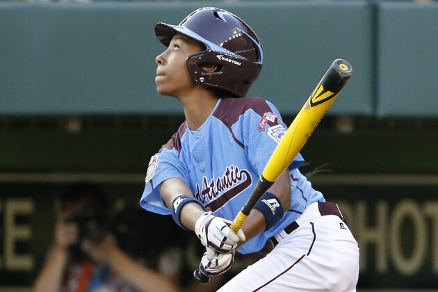 Philadelphia's Mo'ne Davis drives in a run with a single to right field off Pearland  pitcher Clayton Broeder during the first inning of a baseball game in United States pool play at the Little League World Series tournament in South Williamsport, Pa., Sunday, Aug. 17, 2014. (AP Photo/Gene J. Puskar