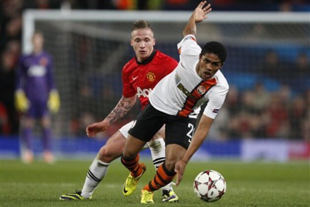 FILE - In this Tuesday, Dec. 10, 2013 file photo, Donetsk's Douglas Costa, right, gets away from Manchester United's Alexander Buttner during their Champions League group A soccer match between Manchester United and Shakhtar Donetsk at Old Trafford Stadium, Manchester, England. Six South Americans - including Costa - have refused to return to Ukraine to play for their football club in Donetsk as conflict rages around the city, risking possible fines and suspensions for breach of contract. (AP Photo/Jon Super, File)