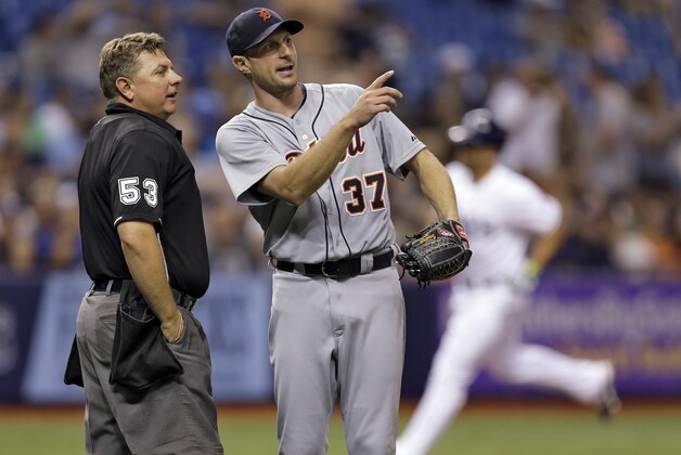 Detroit Tigers starting pitcher Max Scherzer (37) points as he talks with home plate umpire Greg Gibson as Tampa Bay Rays' Vince Belnome rounds the bases on what was originally ruled a home run during the fourth inning of a baseball game Tuesday, Aug. 19, 2014, in St. Petersburg, Fla. The call was overturned on a video review and ruled foul. (AP Photo/Chris O'Meara)