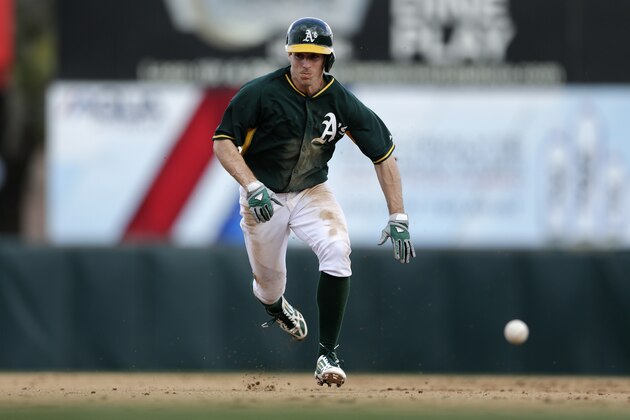 Oakland Athletics invitee Billy Burns heads for third base as a ground ball for a single by invitee Luke Montz passes by while playing the Oakland Athletics during the eighth inning of a spring exhibition baseball game on Saturday, March 1, 2014, in Phoenix. (AP Photo/Gregory Bull)