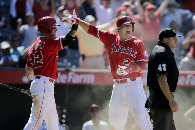Los Angeles Angels' Mike Trout, right, and Josh Hamilton celebrate after Trout scored on a double hit by Albert Pujols during the ninth inning of a baseball game against the Seattle Mariners on Sunday, July 20, 2014, in Anaheim, Calif. The Angels won 6-5. (AP Photo/Jae C. Hong)