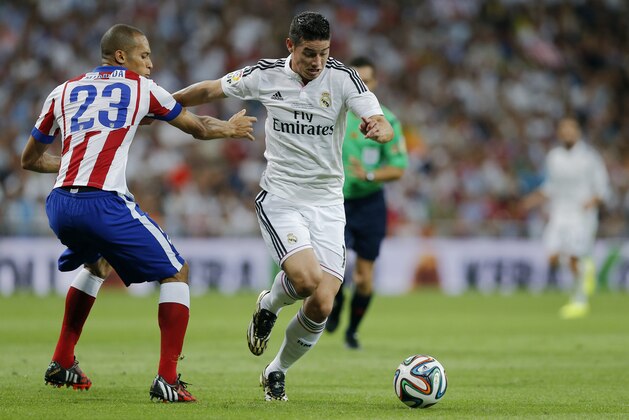 Real Madrid's James Rodriguez from Colombia, fights for the ball with Atletico Madrid's Joao Miranda from Brazil, left, during a Spanish Super Cup soccer match at Santiago Bernabeu stadium  in Madrid, Spain, Tuesday, Aug. 19, 2014 . (AP Photo/Daniel Ochoa de Olza)
