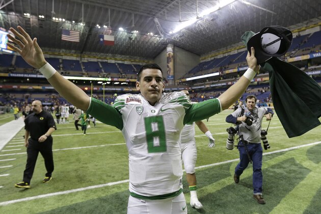 Oregon's Marcus Mariota runs toward fans following the Valero Alamo Bowl NCAA college football game against Texas, Monday,  Dec. 30, 2013, in San Antonio. Oregon won 30-7. (AP Photo/Eric Gay)