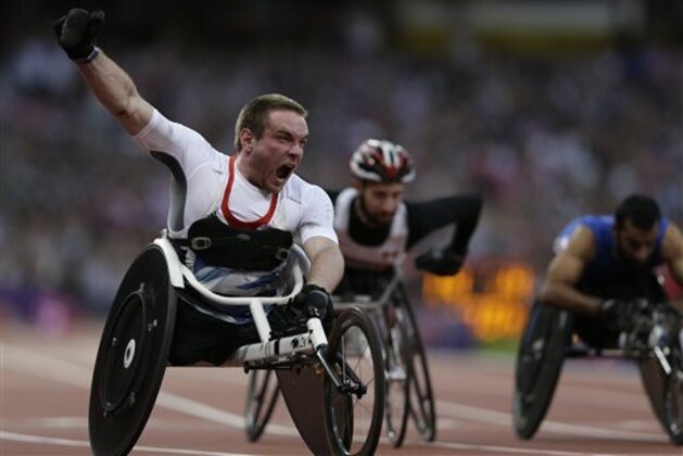 Britain's Mickey Bushell celebrates winning the men's 100m T53 event at the 2012 Paralympics, Monday, Sept. 3, 2012, in London. (AP Photo/Kirsty Wigglesworth)