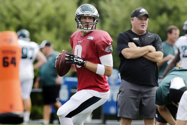 Philadelphia Eagles quarterback Nick Foles fades back to throw as head coach Chip Kelly, right, stands near during an NFL Football training camp scrimmage of the New England Patriots and Eagles in Foxborough, Mass., Tuesday, Aug. 12, 2014. (AP Photo/Charles Krupa)