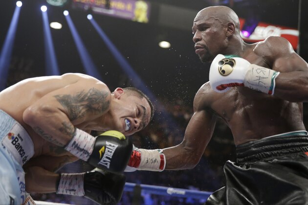 Floyd Mayweather Jr., right, connects with a right to the head of Marcos Maidana, from Argentina, in their WBC-WBA welterweight title boxing fight Saturday, May 3, 2014, in Las Vegas. (AP Photo/Isaac Brekken)