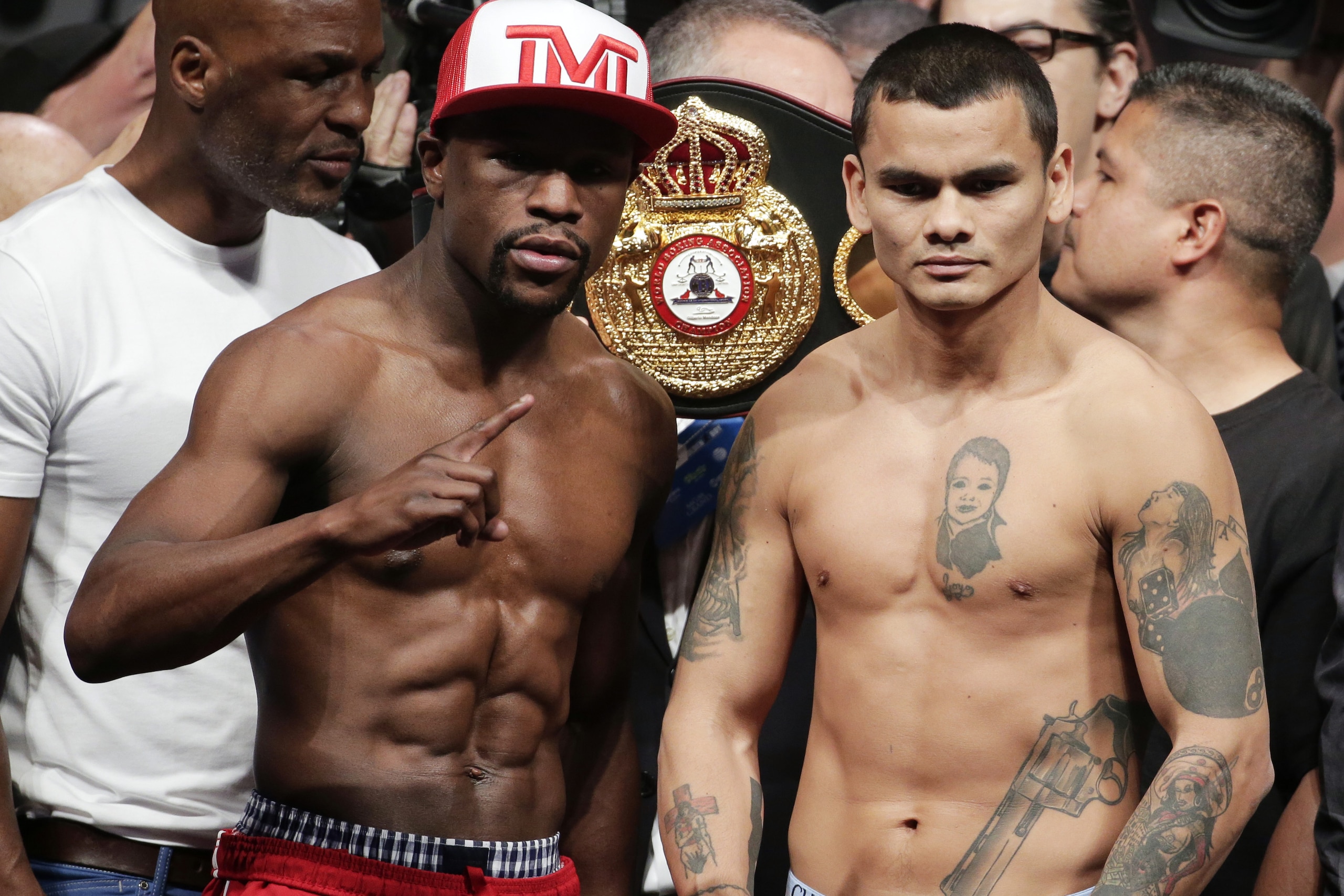 Floyd Mayweather Jr., left, poses on the scales with Marcos Maidana during the official weigh-in at the MGM Grand Hotel in Las Vegas, Friday, May 2, 2014. Mayweather is to face Maidana in a welterweight title fight on Saturday. (AP Photo/Chris Carlson)