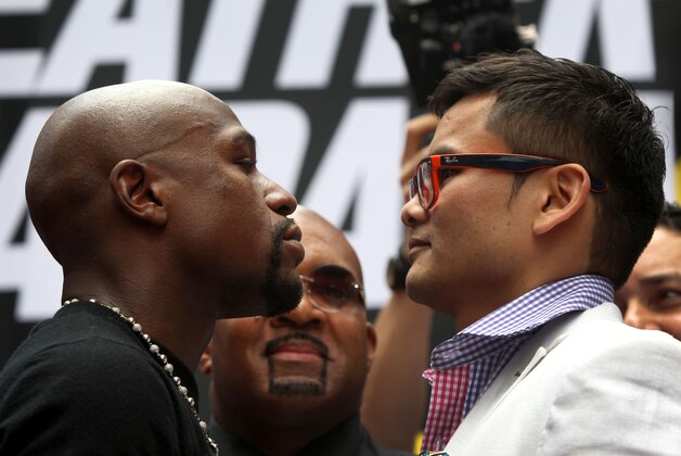 Jul 14, 2014; New York, NY, USA;  Floyd Mayweather Jr. and Marcos Maidana (right) stare at each other during face off to promote their upcoming welterweight rematch during a press conf at Times Square. Mandatory Credit: Noah K. Murray-USA TODAY Sports