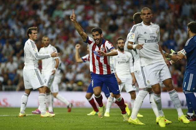 Atletico's Raul Garcia, center, celebrates his goal during a Spanish Supercup first leg soccer match between Real Madrid and Atletico Madrid at the Santiago Bernabeu stadium in Madrid, Spain, Tuesday, Aug. 19, 2014. (AP Photo/Andres Kudacki)