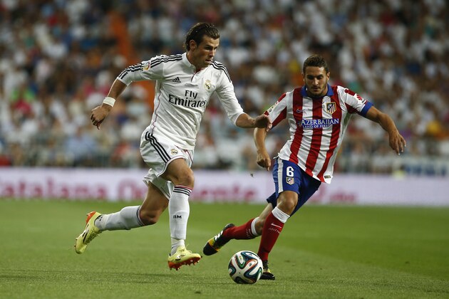 Real's Gareth Bale from Great Britain,  left, in action with Atletico's Koke, right, during a Spanish Supercup first leg soccer match between Real Madrid and Atletico Madrid at the Santiago Bernabeu stadium in Madrid, Spain, Tuesday, Aug. 19, 2014. (AP Photo/Andres Kudacki)