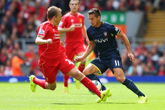 LIVERPOOL, ENGLAND - AUGUST 17: Dusan Tadic of Southampton takes on Lucas Leiva of Liverpool during the Barclays Premier League match between Liverpool and Southampton at Anfield on August 17, 2014 in Liverpool, England.  (Photo by Alex Livesey/Getty Images)
