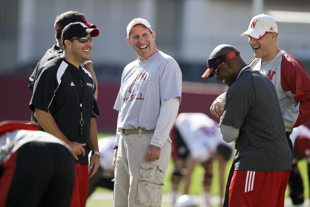 Nebraska head coach Bo Pelini, center, laughs with members of his staff during team practice in Lincoln, Neb., Wednesday, Aug. 13, 2014. (AP Photo/Nati Harnik)