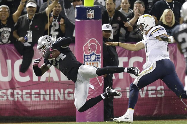 Oakland Raiders cornerback Charles Woodson (24) dives past San Diego Chargers quarterback Philip Rivers to score a touchdown on a fumble recovery during the third quarter of an NFL football game in Oakland, Calif., Sunday, Oct. 6, 2013. (AP Photo/Tony Avelar)