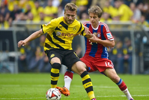 Dortmund's Ciro Immobile and Bayern's Gianluca Gaudino challenge for the ball with during the German soccer Super Cup match between Borussia Dortmund and Bayern Munich in Dortmund, Germany, Wednesday, Aug. 13, 2014. (AP Photo/Sascha Schuermann)