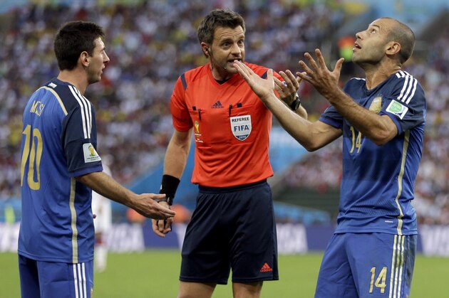 Argentina's Javier Mascherano (14) and Lionel Messi argue with referee Nicola Rizzoli from Italy after Gonzalo Higuain collided with Germany's goalkeeper Manuel Neuer during the World Cup final soccer match between Germany and Argentina at the Maracana Stadium in Rio de Janeiro, Brazil, Sunday, July 13, 2014. (AP Photo/Natacha Pisarenko)