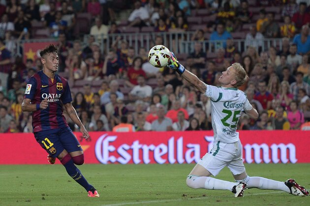 Barcelona's Neymar, from Brazil, left, scores against Leon's goalkeeper Wiliam Yarbrough during the Joan Gamper trophy friendly soccer match at the Camp Nou in Barcelona, Spain, Monday, Aug. 18, 2014. (AP Photo/Manu Fernandez)
