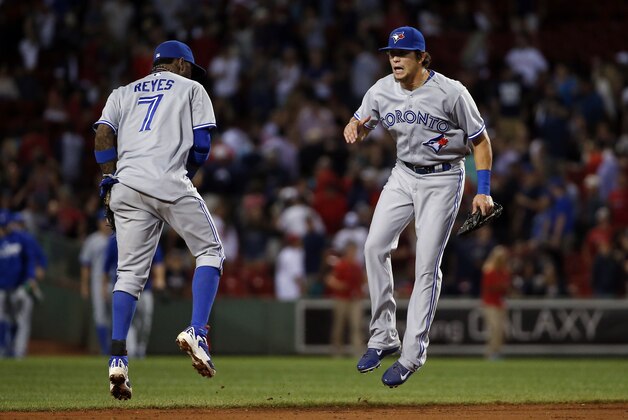 Toronto Blue Jays shortstop Jose Reyes (7) and center fielder Colby Rasmus celebrate after their 6-1 victory over the Boston Red Sox in a baseball game at Fenway Park in Boston, Wednesday, July 30, 2014. (AP Photo/Elise Amendola)