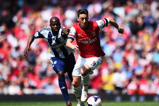 LONDON, ENGLAND - MAY 04:  Mesut Ozil (R) of Arsenal holds off the challenge of Youssuf Mulumbu (L) of West Bromwich Albion during the Barclays Premier League match between Arsenal and West Bromwich Albion at the Emirates Stadium on May 4, 2014 in London, England.  (Photo by Shaun Botterill/Getty Images)