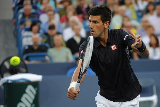 CINCINNATI, OH - AUGUST 12:  Novak Djokovic of Serbia returns to Gilles Simon of France during a match on day 4 of the Western & Southern Open on August 12, 2014 in Cincinnati, Ohio.  (Photo by Jonathan Moore/Getty Images)