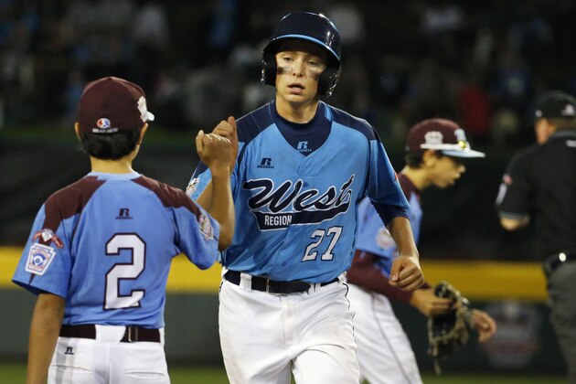 Las Vegas' Brennan Holligan (27) is greeted by Philadelphia third baseman Jack Rice (2) as he rounds third after hitting a two-run home run off  Philadelphia pitcher Carter Davis in sixth inning of a United States semi-final baseball game at the Little League World Series tournament in South Williamsport, Pa., Wednesday, Aug. 20, 2014. Las Vegas won 8-1. (AP Photo/Gene J. Puskar)