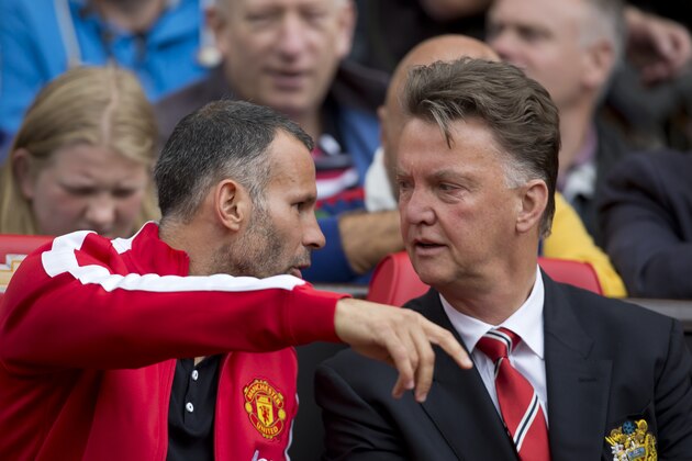 Manchester United's manager Louis van Gaal, right, takes his seat alongside assistant coach Ryan Giggs before the team's English Premier League soccer match against Swansea City at Old Trafford Stadium, Manchester, England, Saturday Aug. 16, 2014. (AP Photo/Jon Super)