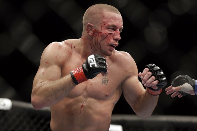 Georges St. Pierre, of Canada, fights Johny Hendricks during a UFC 167 mixed martial arts championship welterweight bout on Saturday, Nov. 16, 2013, in Las Vegas. St. Pierre won by split decision. (AP Photo/Isaac Brekken)