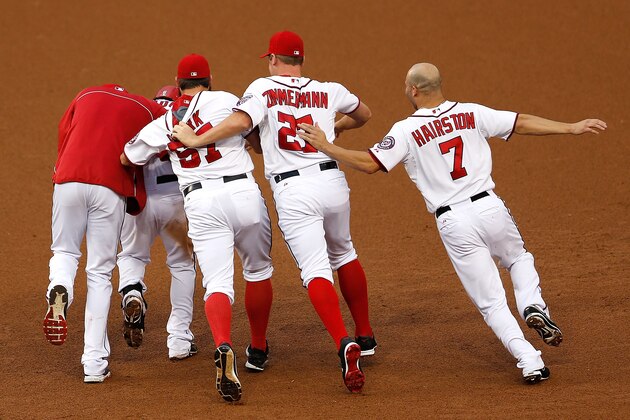 WASHINGTON, DC - AUGUST 21:  Teammates mob Anthony Rendon #6 of the Washington Nationals after he knocked in the winning run against the Arizona Diamondbacks in the ninth inning at Nationals Park on August 21, 2014 in Washington, DC. The Nationals won the game 1-0, their tenth victory in a row.  (Photo by Win McNamee/Getty Images)