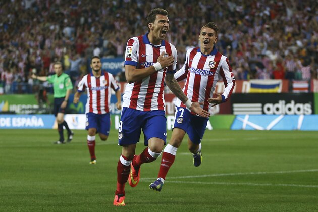 Atletico's Mandzukic, centre, celebrates his goal with team mates during a Spanish Supercup second leg soccer match between Real Madrid and Atletico Madrid at Vicente Calderon stadium in Madrid, Spain, Friday, Aug. 22, 2014. (AP Photo/Andres Kudacki)