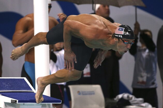 Michael Phelps of the U.S. dives in during his men's 4 x 100m freestyle final at the Pan Pacific swimming championships in Gold Coast, Australia, Saturday, Aug. 23, 2014.  Australia won the race ahead of the U.S. and Brazil.(AP Photo/Rick Rycroft)