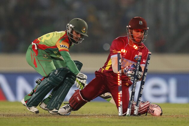 West Indies' wicketkeeper Lendl Simmons, right, attempts unsucessfully to dismiss Bangladesh batsman Mominul Haque, left, during their ICC Twenty20 Cricket World Cup match in Dhaka, Bangladesh, Tuesday, March 25, 2014. (AP Photo/Aijaz Rahi)