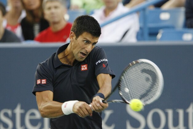 Aug 12, 2014; Cincinnati, OH, USA; Novak Djokovic returns the serve of Gilles Simon on day two of the Western and Southern Open tennis tournament at Linder Family Tennis Center. Mandatory Credit: Mark Zerof-USA TODAY Sports
