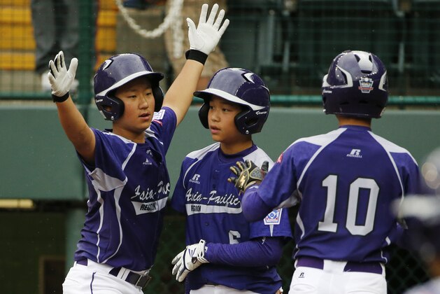 South Korea's Jae Yeong Hwang, left, celebrates with teammates Dong Hwan Ahn, center, and Ji Ho Park (10) after all three scored on an RBI double by Dong Wan Sin in the second inning against Japan in the International Championship baseball game at the Little League World Series tournament in South Williamsport, Pa., Saturday, Aug. 23, 2014.  (AP Photo/Gene J. Puskar)