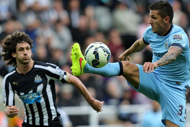 Manchester City's Steven Jovetic, right, vies for the ball with Newcastle United's captain Fabricio Coloccini, left, during their English Premier League soccer match at St James' Park, Newcastle, England, Sunday, Aug. 17, 2014. (AP Photo/Scott Heppell)