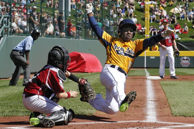 Chicago's Danon Radcliff, right, is tagged out attempting to score by Lynnwood, Washington catcher Robley Corsi III during the first inning of a Little League baseball game in United States pool play at the Little League World Series tournament in South Williamsport, Pa., Thursday, Aug. 14, 2014. Chicago won 12-2. (AP Photo/Gene J. Puskar)
