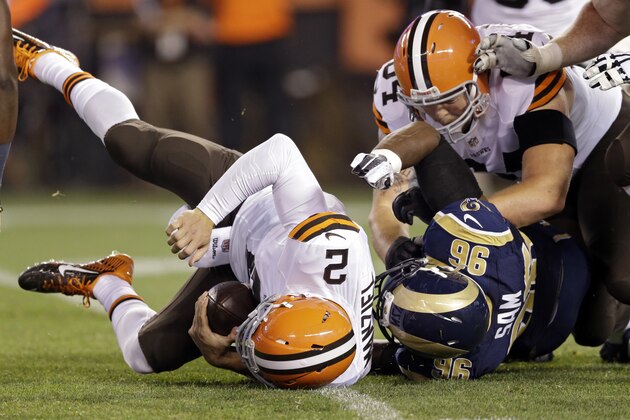 Cleveland Browns quarterback Johnny Manziel (2) is sacked by St. Louis Rams defensive end Michael Sam (96) in the fourth quarter of a preseason NFL football game Saturday, Aug. 23, 2014, in Cleveland. (AP Photo/Tony Dejak)