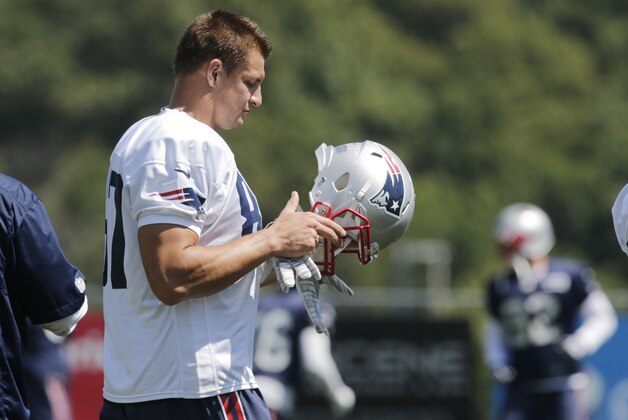 New England Patriots tight end Rob Gronkowski (87) puts on his helmet during an NFL football practice in Foxborough, Mass., Wednesday, Aug. 20, 2014. (AP Photo/Charles Krupa)