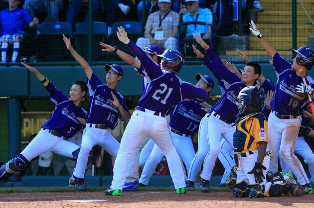 SOUTH WILLIAMSPORT, PA - AUGUST 24: Hae Chan Choi #21 of  Team Asia-Pacific celebrates with teammates after hitting a solo home run against the Great Lakes Team from Chicago, Illinois during the sixth inning of the Little League World Series Championship game at Lamade Stadium on August 24, 2014 in South Williamsport, Pennsylvania.  (Photo by Rob Carr/Getty Images)