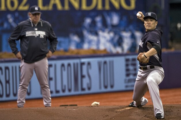 New York Yankees pitching coach Larry Rothschild, left, watches pitcher Masahiro Tanaka, right, throw in the bullpen before a baseball game between the Yankees and the Tampa Bay Rays Saturday, Aug. 16, 2014 in St. Petersburg, Fla. (AP Photo/Steve Nesius)