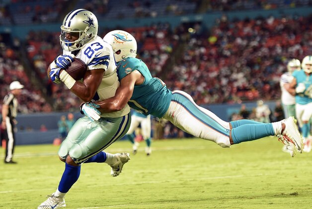 Aug 23, 2014; Miami Gardens, FL, USA; Miami Dolphins cornerback Brent Grimes (21) tackles Dallas Cowboys wide receiver Terrance Williams (83) in the second quarter of the game at Sun Life Stadium. Mandatory Credit: Brad Barr-USA TODAY Sports