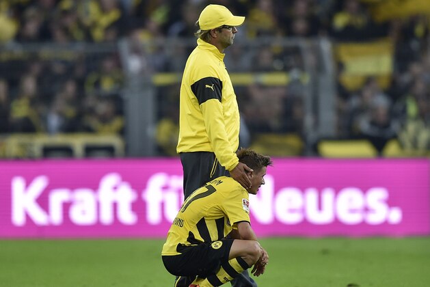 Dortmund's head coach Juergen Klopp comforts player Erik Durm after the German Bundesliga soccer match between Borussia Dortmund and Bayer Leverkusen in Dortmund,  Germany, Saturday, Aug. 23, 2014. Borussia was defeated by Bayer with 0-2. (AP Photo/Martin Meissner)