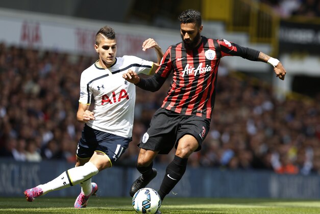 Tottenham Hotspur's Erik Lamela, left, competes for the ball with Queens Park Rangers' Armand Traore during their English Premier League soccer match at White Hart Lane, London, Sunday, Aug. 24, 2014. (AP Photo/Sang Tan)