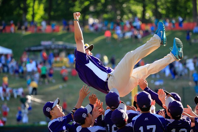 SOUTH WILLIAMSPORT, PA - AUGUST 24:  Members of Team Asia-Pacific (L) throw an assistant coach in the air following their 8-4 win over the Great Lakes Team from Chicago, Illinois to win the Little League World Series Championship game at Lamade Stadium on August 24, 2014 in South Williamsport, Pennsylvania.  (Photo by Rob Carr/Getty Images)