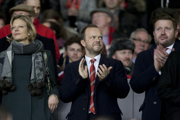 Manchester United chief executive Ed Woodward, centre, applauds before the team's English Premier League soccer match against Tottenham at Old Trafford Stadium, Manchester, England, Wednesday Jan. 1, 2014. (AP Photo/Jon Super)