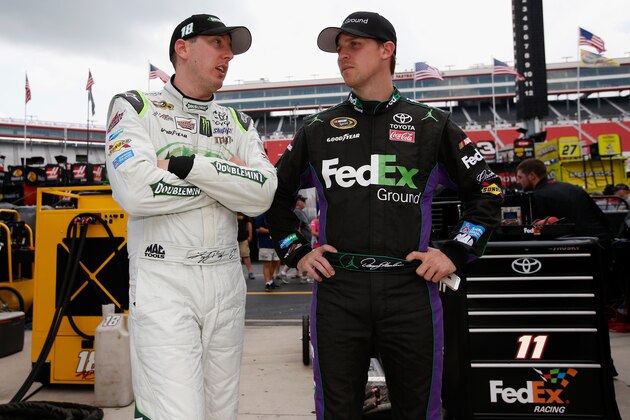 BRISTOL, TN - AUGUST 22: Kyle Busch, driver of the #18 Doublemint Toyota, speaks with Denny Hamlin, driver of the #11 FedEx Ground Toyota, in the garage area during practice for the NASCAR Sprint Cup Series Irwin Tools Night Race at Bristol Motor Speedway on August 22, 2014 in Bristol, Tennessee.  (Photo by Gregory Shamus/Getty Images)