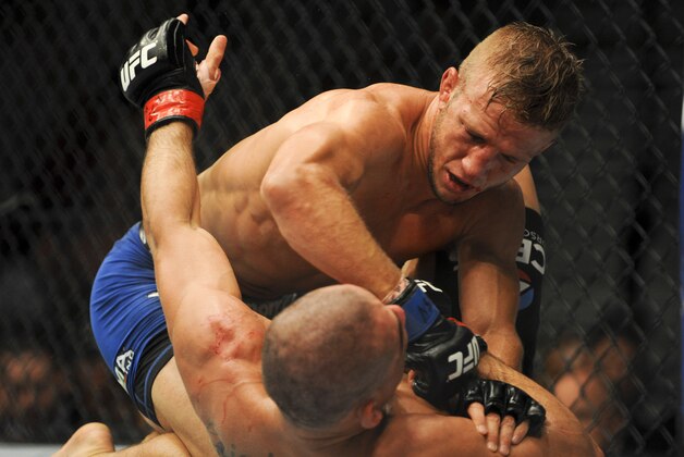 May 24, 2014; Las Vegas, NV, USA; TJ Dillashaw (blue) pins down  Renan Barao (red) during their UFC 173 bantamweight championship bout at MGM Grand Garden Arena. Dillashaw won the bout by way of TKO. Mandatory Credit: Stephen R. Sylvanie-USA TODAY Sports