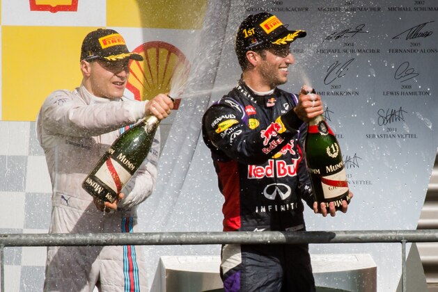 Red Bull driver Daniel Ricciardo of Australia, right, and Williams driver Valtteri Bottas of Finland spray champagne as they stand on the podium after the Belgian Formula One Grand Prix in Spa-Francorchamps, Belgium, Sunday, Aug. 24, 2014. Red Bull driver Daniel Ricciardo of Australia won the race, Mercedes driver Nico Rosberg of Germany finished second and Williams driver Valtteri Bottas of Finland third. (AP Photo/Geert Vanden Wijngaert)