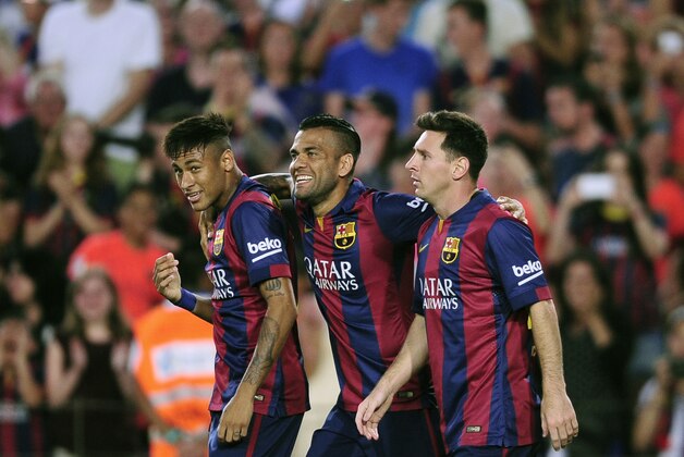 Barcelona's Lionel Messi, from Argentina, right, reacts after scoring with his teammates Neymar, from Brazil, left, and Dani Alves, against Leon during the Joan Gamper trophy friendly soccer match at the Camp Nou in Barcelona, Spain, Monday, Aug. 18, 2014. (AP Photo/Manu Fernandez)