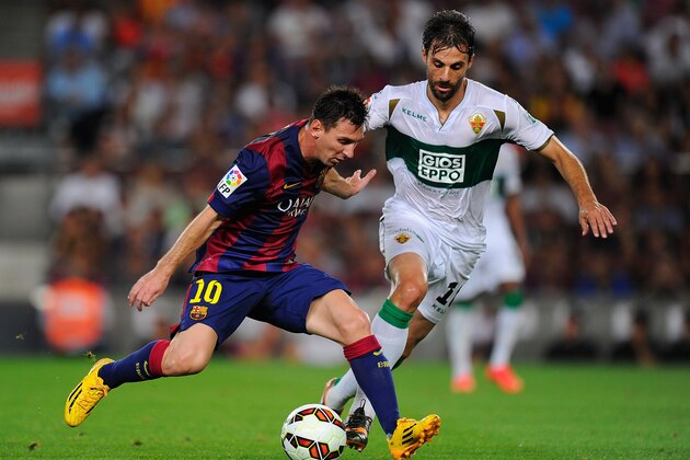 BARCELONA, SPAIN - AUGUST 24:  Lionel Messi of FC Barcelona takes on Sergio Pelegrin of Elche FC during the La Liga match between FC Barcelona and Elche FC at Camp Nou stadium on August 24, 2014 in Barcelona, Spain.  (Photo by Denis Doyle/Getty Images)
