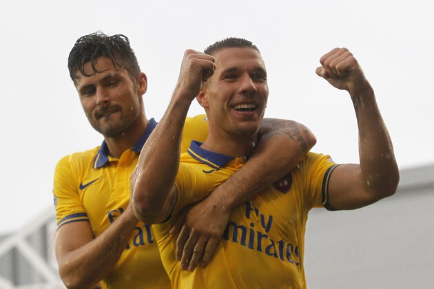 Arsenal's Lukas Podolski, right, celebrates his second goal against Fulham with teammate Olivier Giroud during their English Premier League soccer match at Craven Cottage, London, Saturday, Aug. 24, 2013. (AP Photo/Sang Tan)